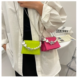 Detail of neon green and rose red PU leather handbags with heart pearl chain straps