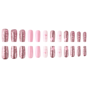 Detailed flat lay of pink square press-on nails with heart patterns and glitter finish