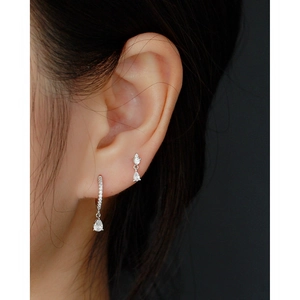 Macro shot of S925 silver hoop earrings with water drop zircon pendants on ear