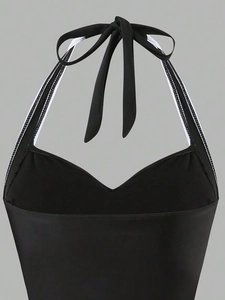 Detail of black V-neck lace-up swimsuit with white stripe trim and textured fabric