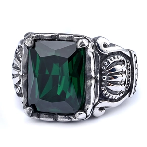 Macro detail of vintage gothic ring featuring a large emerald green stone on carved steel