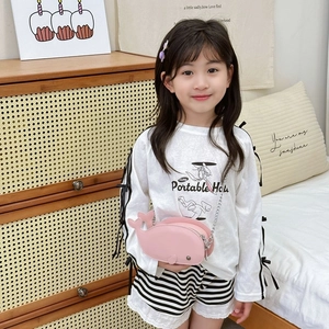 Pink dolphin-shaped crossbody bag with chain strap worn by a young child model