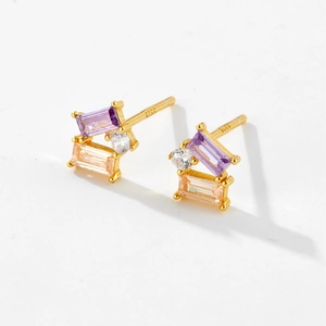 Macro detail of S925 silver stud earrings with purple and champagne cubic zirconia