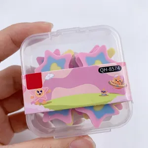 Primer plano de gomas de borrar con forma de estrella en caja transparente rosa azul