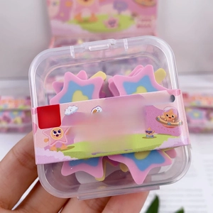 Close-up of star-shaped erasers in a transparent box, pink blue and yellow colors