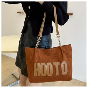 Detail of brown faux suede tote bag with HOOTO letter embroidery and chain strap