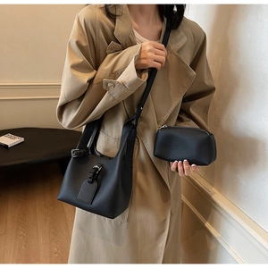 Détail du sac seau noir à texture litchi avec bandoulière et petite pochette interne