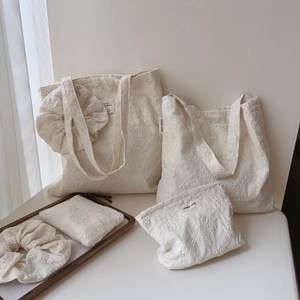 Close-up of five-piece cream cotton set with exquisite floral embroidery and fabric labels