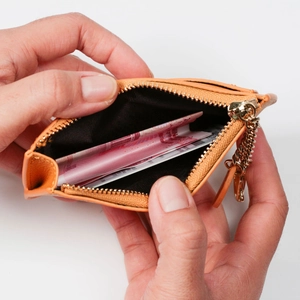 Compact orange leather coin purse with golden zipper and spacious inner compartment