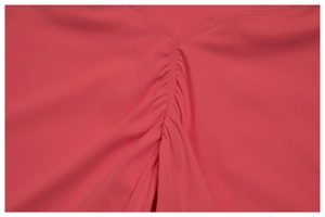 Détail de la couture en V et du plissage sur le short de yoga rose corail extensible