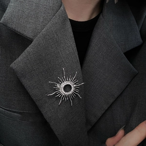 18k gold plated sunburst brooch with clear zircons on dark blazer lapel for women