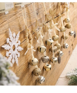 Close-up of festive gold and silver bells with star pendants on warm wood background