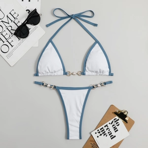 Détail du bikini côtelé blanc avec bordure bleue, anneaux dorés et perles chic