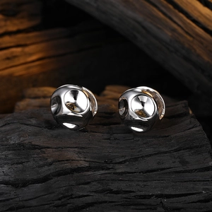 Minimalist silver irregular textured hoop earrings on a vintage dark wood background