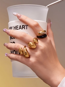 Détail de bagues ouvertes dorées bicolores avec émail noir et accents de zircone