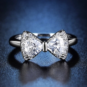 Macro shot of bow-shaped ring with dual triangle diamonds and micro-pave setting