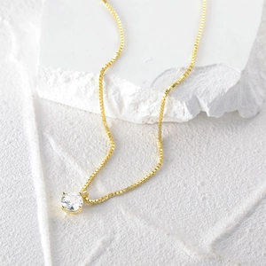 Macro shot of gold S925 sterling silver box chain necklace with 4-prong zircon