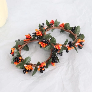 Detail of Halloween candle rings with orange and black berries on festive berry wreath