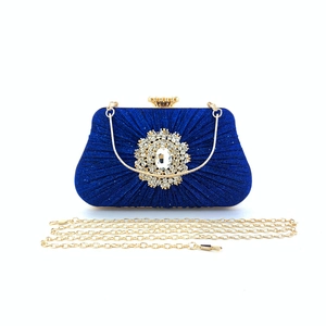 Detail of royal blue pleated satin evening bag with ornate crystal flower embellishment