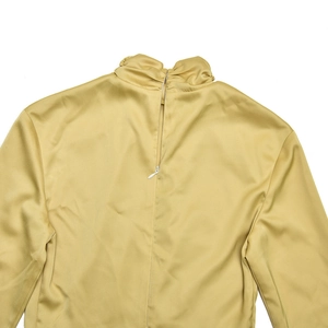 Detail of the invisible back zipper and silky satin fabric on the yellow high-neck dress