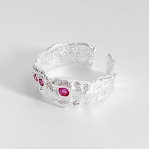 Close-up of irregular hammered texture silver ring with three pink zircon gemstones
