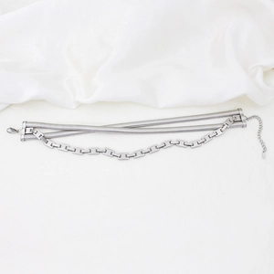 Detail view of multi-layered silver stainless steel snake chains on silk background