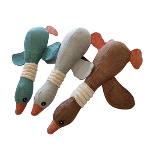 Three squeaky plush dog chew toys in grey, green, and brown with rope knot necks