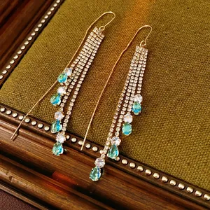 French vintage gold tassel drop earrings with blue zircon stones on velvet tray