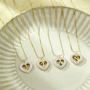 Detail of heart pendants with pavé zircon stones and gold-plated initial letters