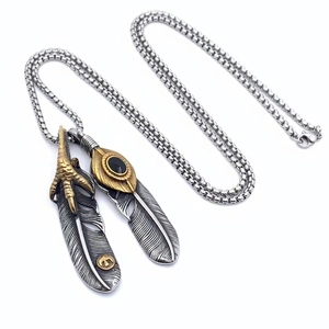 Detailed close-up of retro titanium steel eagle claw feather pendants with turquoise stone
