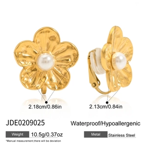 Détail de boucles d'oreilles clips fleurs en acier doré 18K avec perle blanche centrale