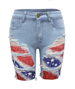 Detail of distressed denim shorts showing ripped holes with American flag patch pattern