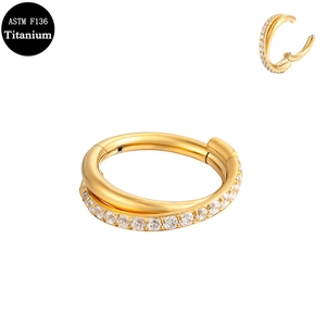 Detail of G23 titanium double crossover nose ring with cubic zirconia in gold finish