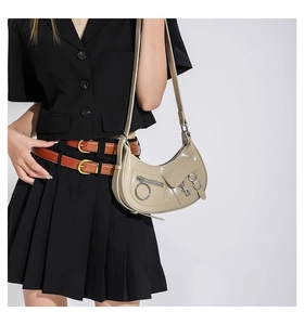 Détail du sac hobo croissant beige avec finition brillante et ornements punk argentés
