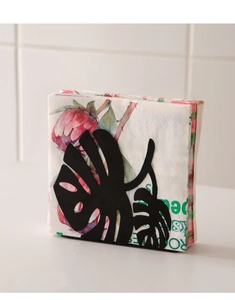 Detail of black metal napkin holder featuring a minimalist monstera leaf hollow design