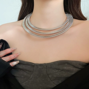 Detail of a three-layer silver spring collar necklace with textured industrial style