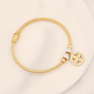 Detail of gold snake chain bracelet with sparkling crystal flower pendant and spacer beads