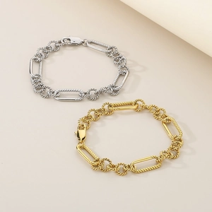 Detailed close-up of gold and silver mixed texture chain bracelets with lobster clasp