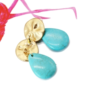 Close-up of golden hammered metal studs and blue turquoise teardrop pendants