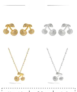 Dettaglio parure di gioielli ciliegia con strass pavé in finitura oro e argento