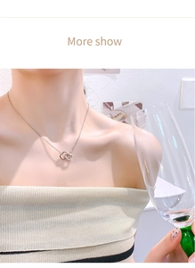Detail view of double heart necklace with crystal accents worn by a female model