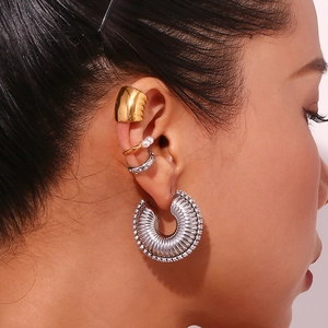 Close-up of mixed metal earrings with pearls and crystals on female model