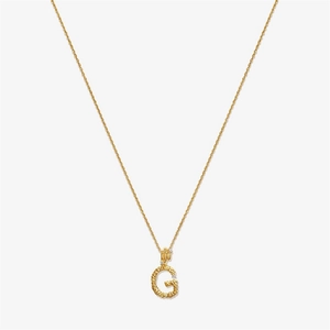 Macro shot of gold textured letter G pendant with sparkling diamond details on a fine chain