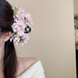 Elegant spring fabric flower hair claw with pink cherry blossoms on brunette hair
