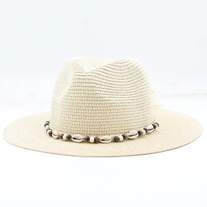 Close-up of Bohemian straw hat featuring real white shells and dark wooden beads trim