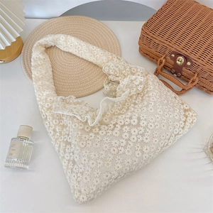 Detail of white lace daisy tote bag with delicate floral crochet and ruffled edges