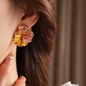 Macro detail of vintage floral earring with red-brown gradient enamel and small crystals
