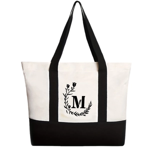 Canvas tote bag with black letter M floral print and contrasting black shoulder straps