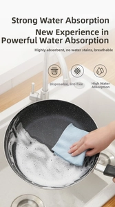 Cleaning a non-stick pan with a blue microfiber kitchen cloth and soapy foam