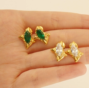 Detail of 18k gold plated starburst earrings with emerald and white marquise stones